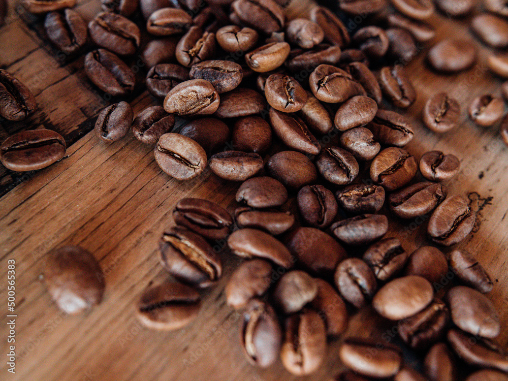 Naklejka premium coffee beans on wooden background