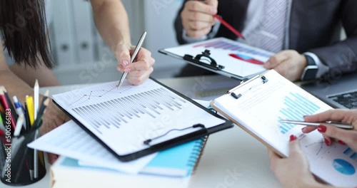 Business team studies financial indicators in charts