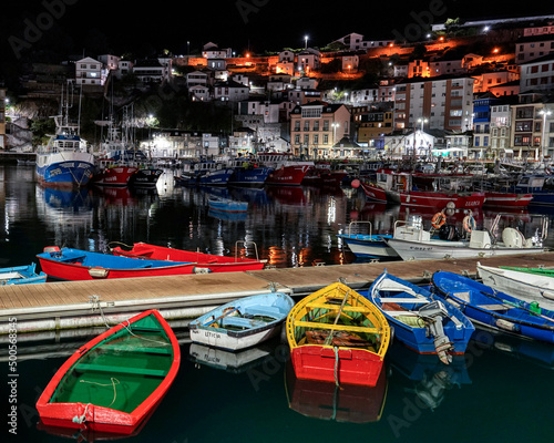 sea pier at night with colorful boats