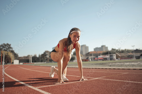 young woman ready on the start of a track