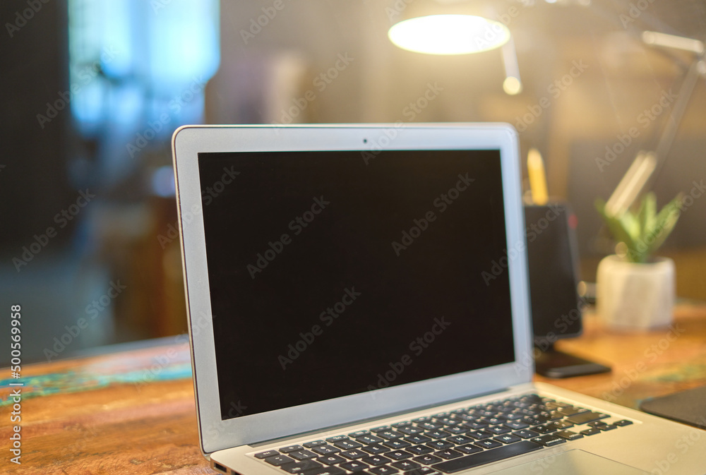Fototapeta premium Home office desk with laptop and phone. Blank screen with copy space.