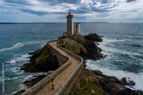 lighthouse du petit minou with a woman walking in a yellow coat.