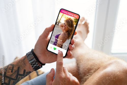 Man using online dating app on his mobile phone photo