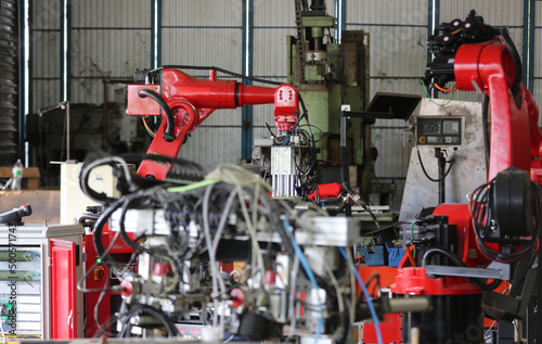 Robotics arm in the metal factory plant . it's performing routine servicing of the welding robotics units equipment. © FotoArtist
