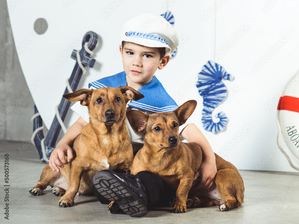 Cabin boy with two small dogs in front of ship
