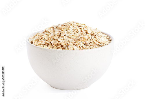 raw oat flakes in light beige plate isolated on white background