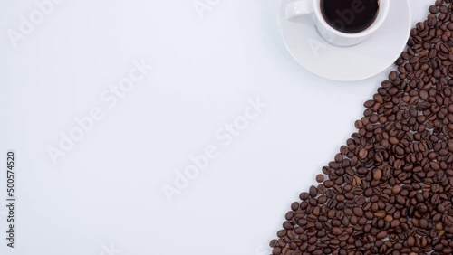 Stop motion animation of a white background filled with coffee beans and a white cup with espresso and a note good morning.