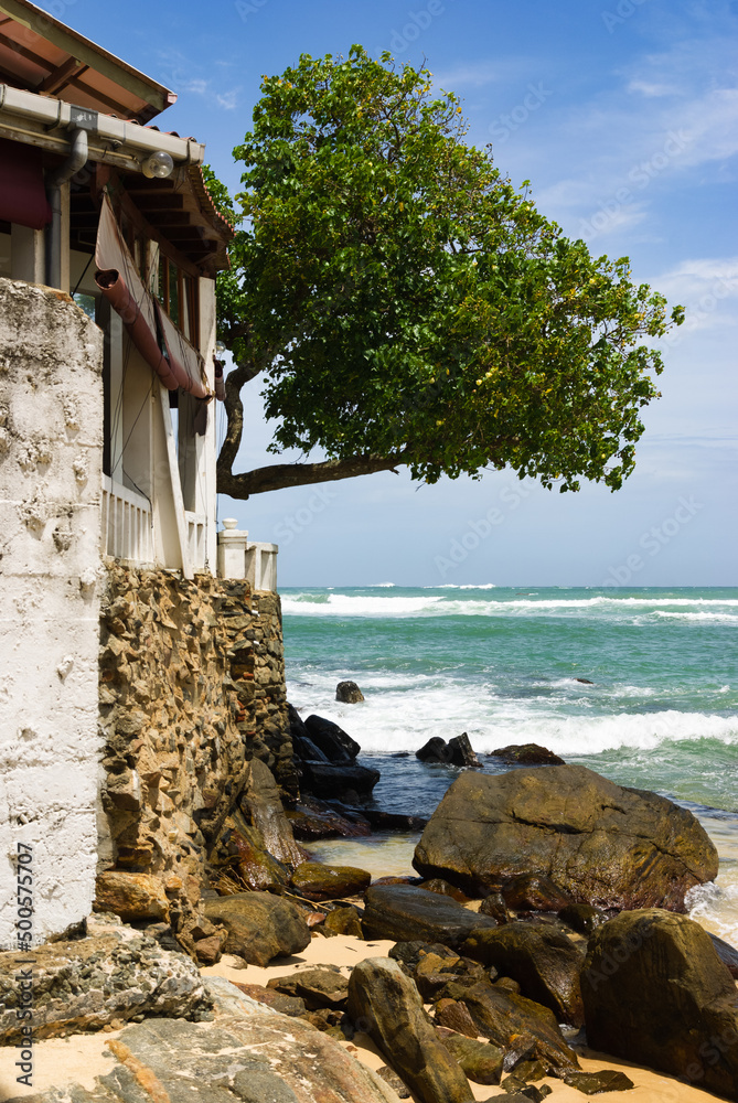 Rocky tropical beach with house, rural Sri Lanka