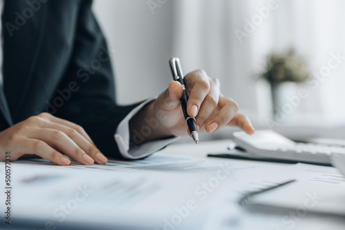 A business finance woman is reviewing a company's financial documents prepared by the Finance Department for a meeting with business partners. Concept of validating the accuracy of financial numbers.