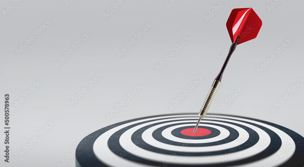 Red dart hit to center of dartboard. Arrow on bullseye in target. Business success, investment goal, opportunity challenge, aim strategy, achievement focus concept. Copy space, banner for advertising Red dart hit to center of dartboard. Arrow on bullseye in target. Business success, investment goal, opportunity challenge, aim strategy, achievement focus concept. Copy space, banner for advertising