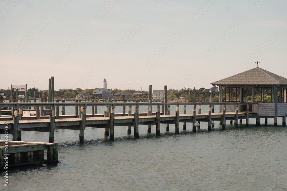 Landscape of Ocracoke Inlet, Lighthouse, Dock, Water and Buildings on Sunny Day