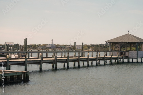 Landscape of Ocracoke Inlet, Lighthouse, Dock, Water and Buildings on Sunny Day © Monica