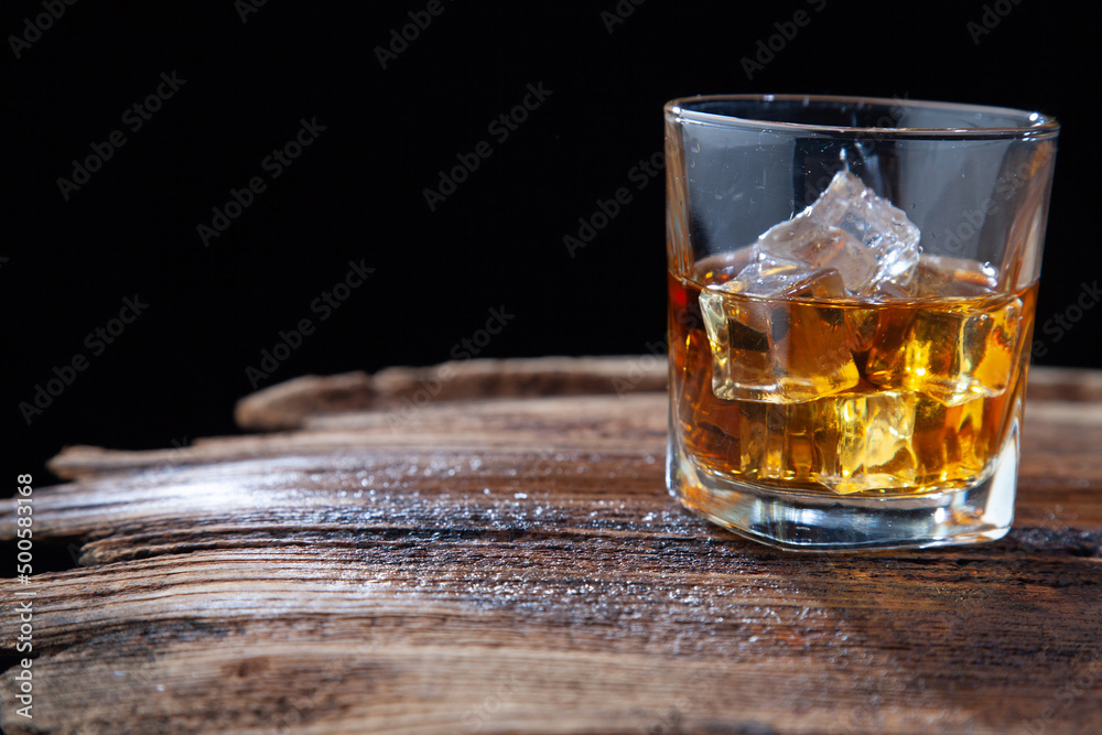 Whiskey or alcoholic beverages or bourbon with ice on the wooden floor and a black and white scene with a top view Whiskey or alcoholic beverages or bourbon with ice on the wooden floor and a black and white scene with a top view