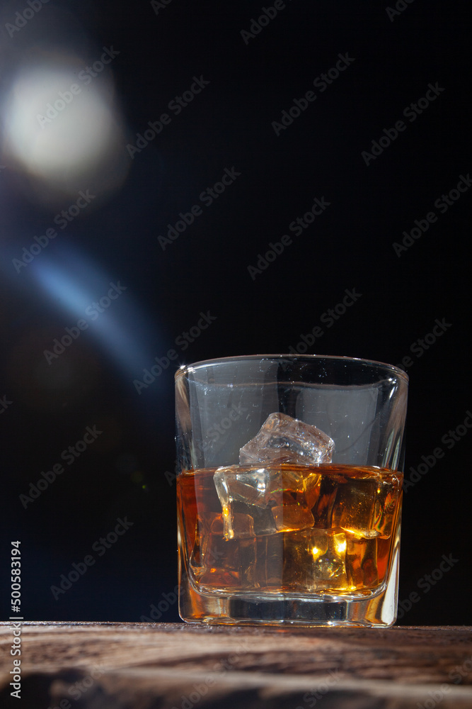 Whiskey or alcoholic beverages or bourbon with ice on the wooden floor and a black and white scene with a top view Whiskey or alcoholic beverages or bourbon with ice on the wooden floor and a black and white scene with a top view
