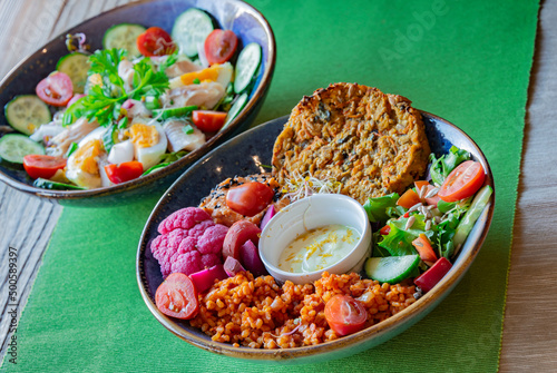 Vegan plate with millet cutlet, bulgur groats and vegetables photo