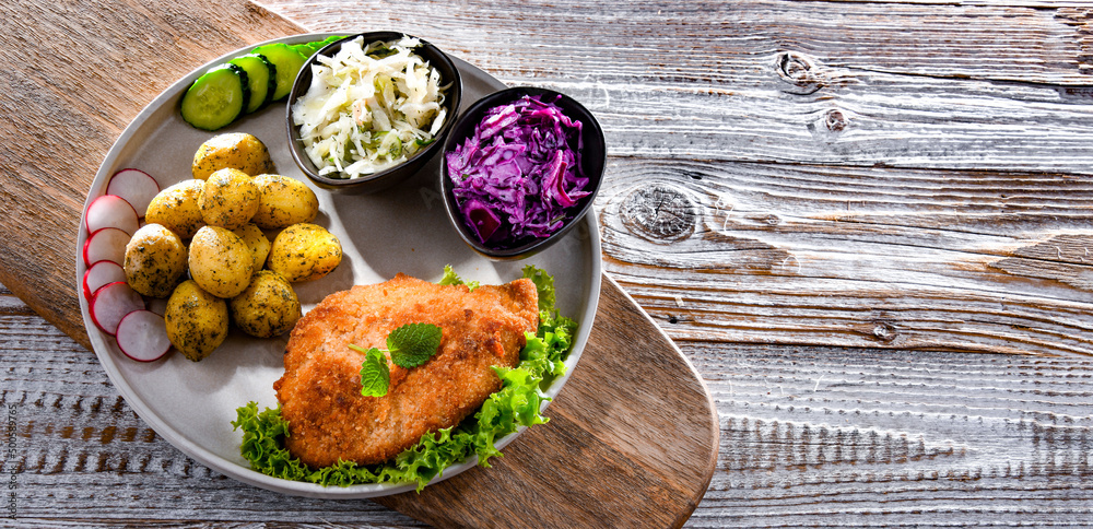 Pork cutlet coated with breadcrumbs with potatoes and salads Pork cutlet coated with breadcrumbs with potatoes and salads