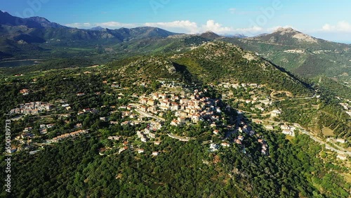 The village of Monticello above the green mountains , in Europe, France, Corsica, by the Mediterranean Sea, in summer, on a sunny day. photo