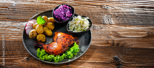 Baked chicken leg with potatoes and vegetable salads