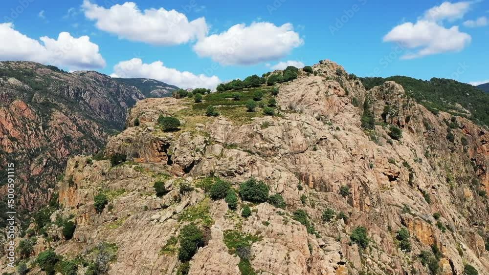 The Porto valley in the middle of the arid countryside with some green vegetation , in Europe, France, Corsica, towards Ajaccio, by the Mediterranean sea, in summer, on a sunny day. The Porto valley in the middle of the arid countryside with some green vegetation , in Europe, France, Corsica, towards Ajaccio, by the Mediterranean sea, in summer, on a sunny day.