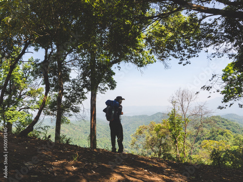 Trekking solo backpack on mountain trail in tropical forest at Tak Province, Thailand. © TongTa