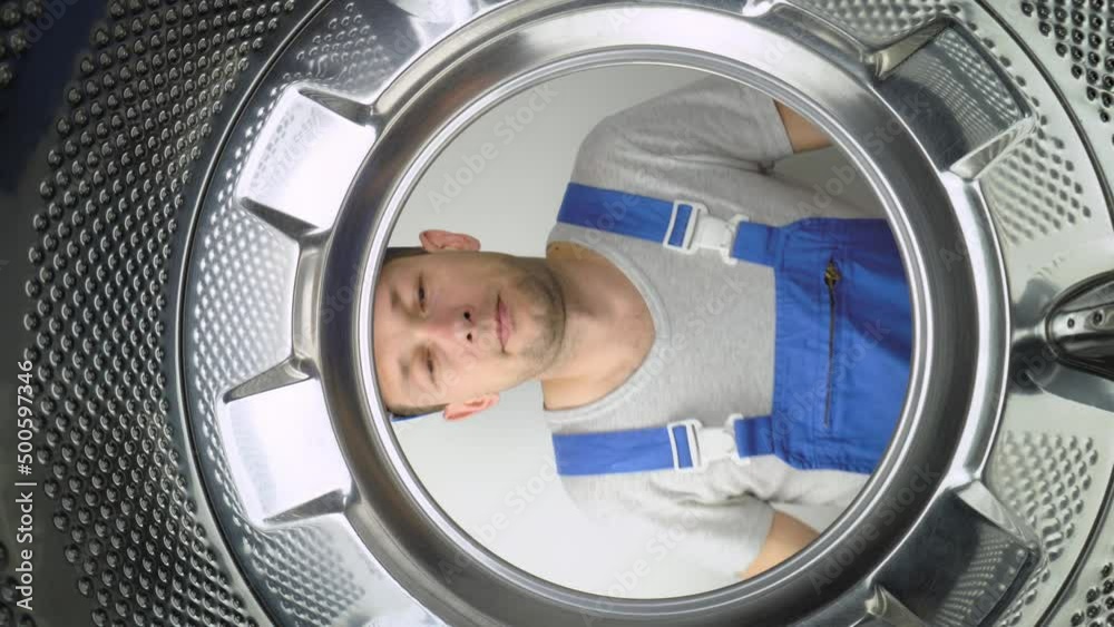 a home appliance washing machine remommer responder looks inside drum of washing machine and points his fingers to gesture or sign all right or okay. Class. Lot of work done. Service men. a home appliance washing machine remommer responder looks inside drum of washing machine and points his fingers to gesture or sign all right or okay. Class. Lot of work done. Service men.