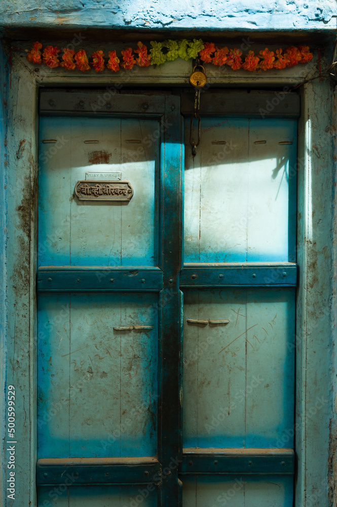 Blue wooden door with name written in devanagari and latin scripts in Pune, India