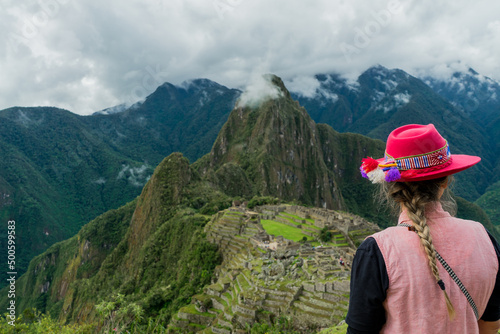 Photograph of Machu Picchu. Woman with Inca hat in the mountains
