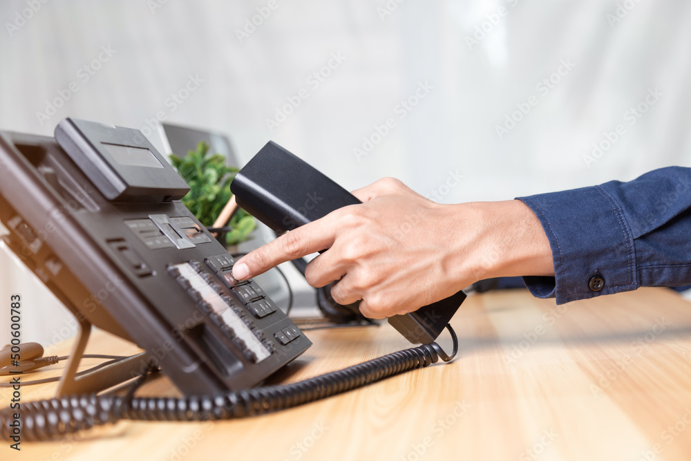 Call center staff man hand point to press the button number on the phone office desk , Communication support, call center and customer service help desk. for (call center) concept