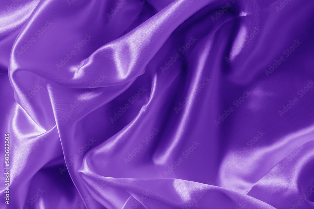 The texture of the proton purple cloth with waves and shrugs. Shiny fabric.