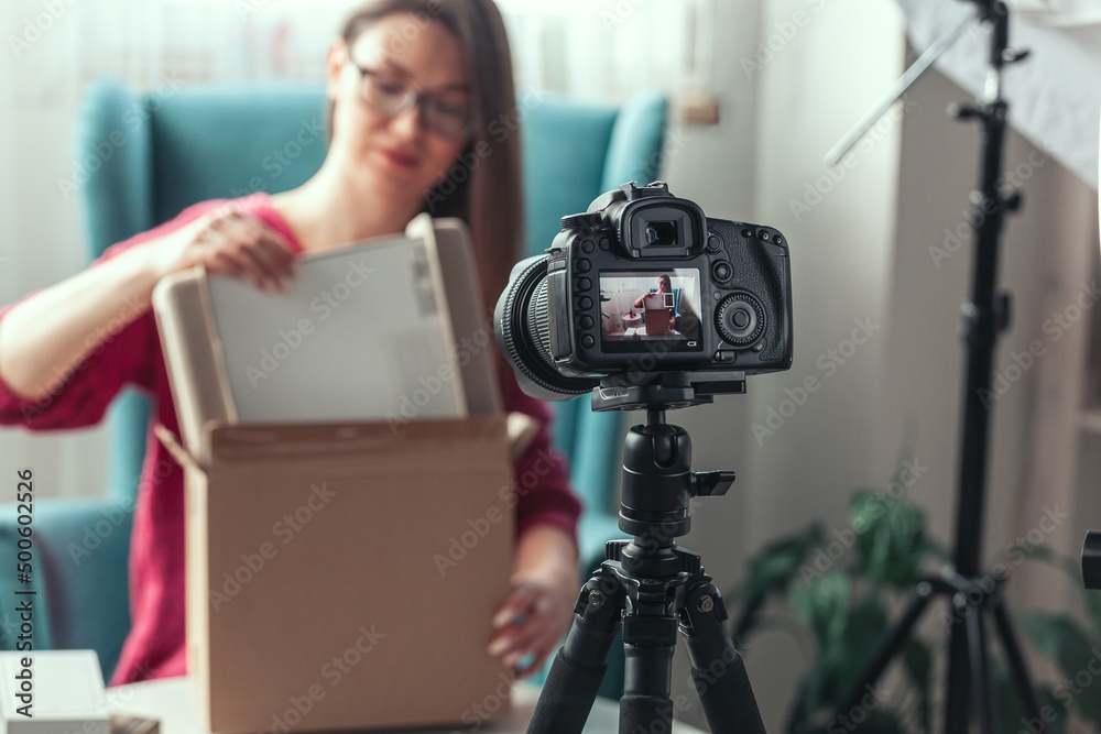 Close-up camera screen, woman blogger makes video of unpacking gadgets at home