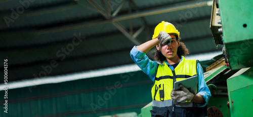 Tired and hot. Portrait african american female engineer worker wearing safety hard hat helmet. Metal lathe industrial manufacturing factory photo