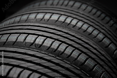 New car tires. Group of road wheels on dark background. Summer Tires with asymmetric tread design. Driving car concept. © bondvit