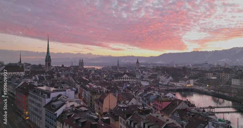 Wide Establishing Aerial Sunset or Sunrise Shot of Zurich City Center Landmark with Twilight Red Sky. Amazing Drone Footage of Switzerland Cityscape Riverside Aerial panorama at night.