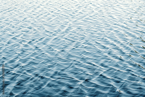 Water surface with ripples and sunlight reflections