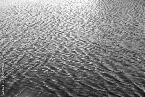 Water surface with ripples and sunlight reflections