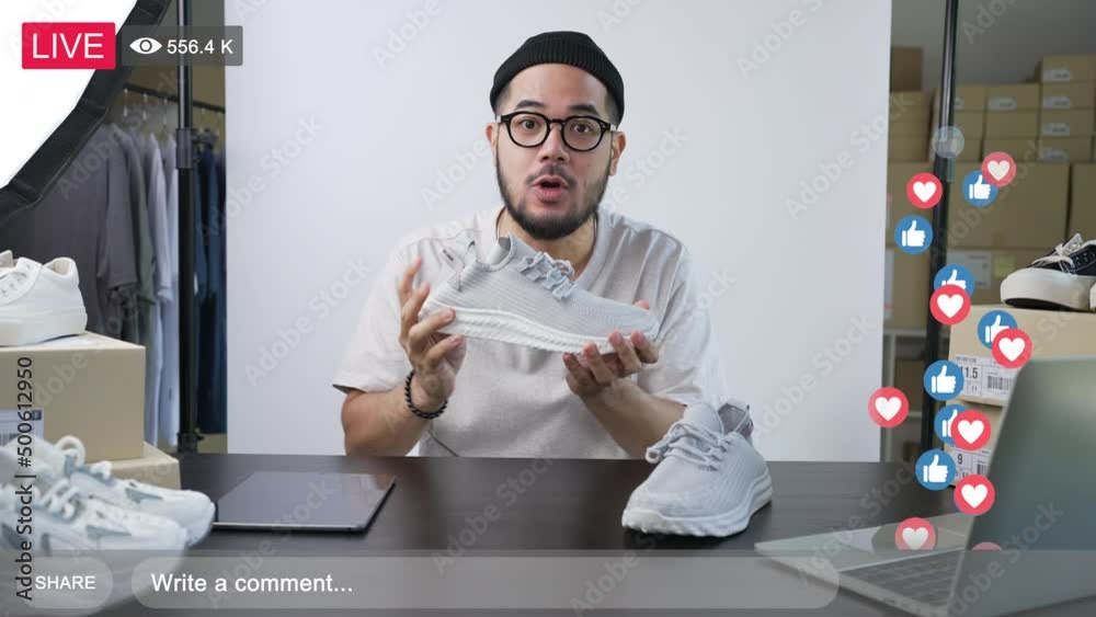 Young attractive Asian man blogger or vlogger looking at camera reviewing product and merchandise. Business online influencer on social media concept.