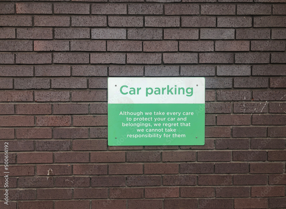 green and white car parking sign on a dark brick background green and white car parking sign on a dark brick background