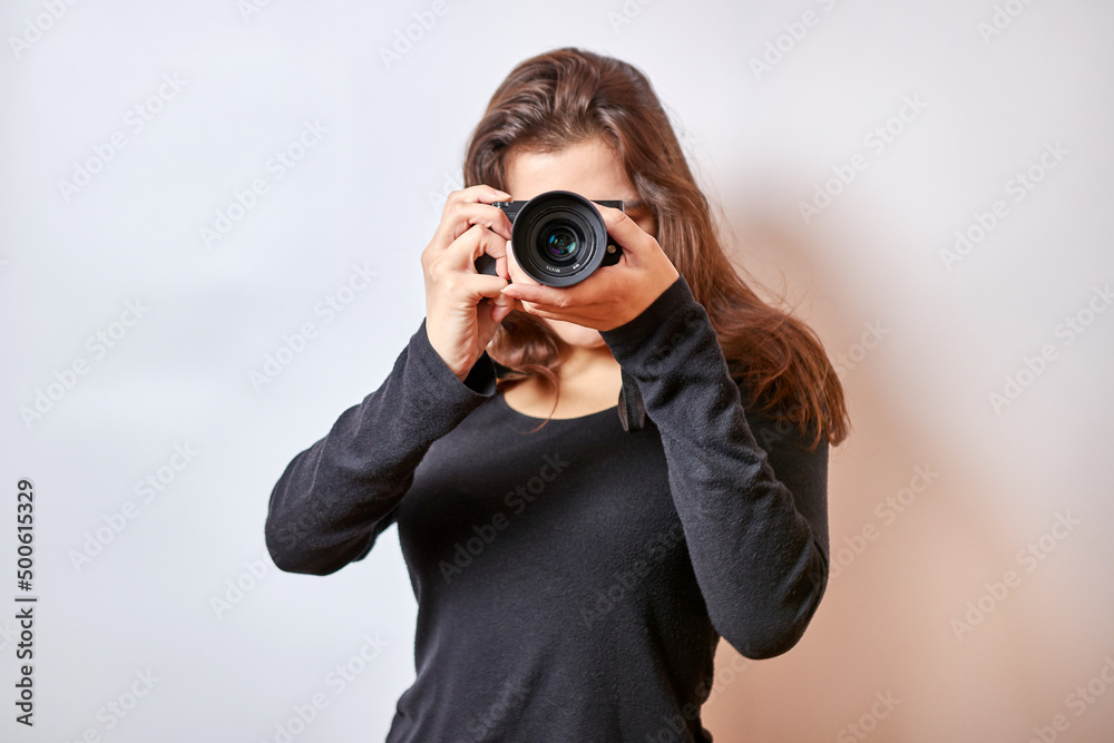 Pretty girl taking pictures with a digital camera holding it to her eye. Pretty girl taking pictures with a digital camera holding it to her eye.