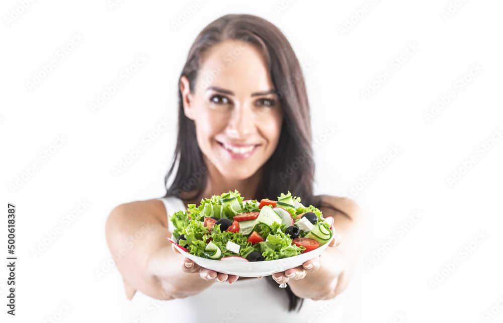 Young attractive brunette showing bowl full of lettuce salad with tomatoes olives cucumber and feta cheese Young attractive brunette showing bowl full of lettuce salad with tomatoes olives cucumber and feta cheese