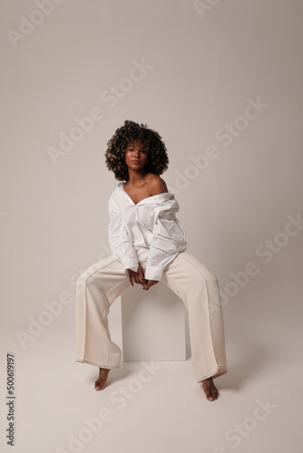 Beautiful woman with afro hairstyle. Carefree female posing on white background.