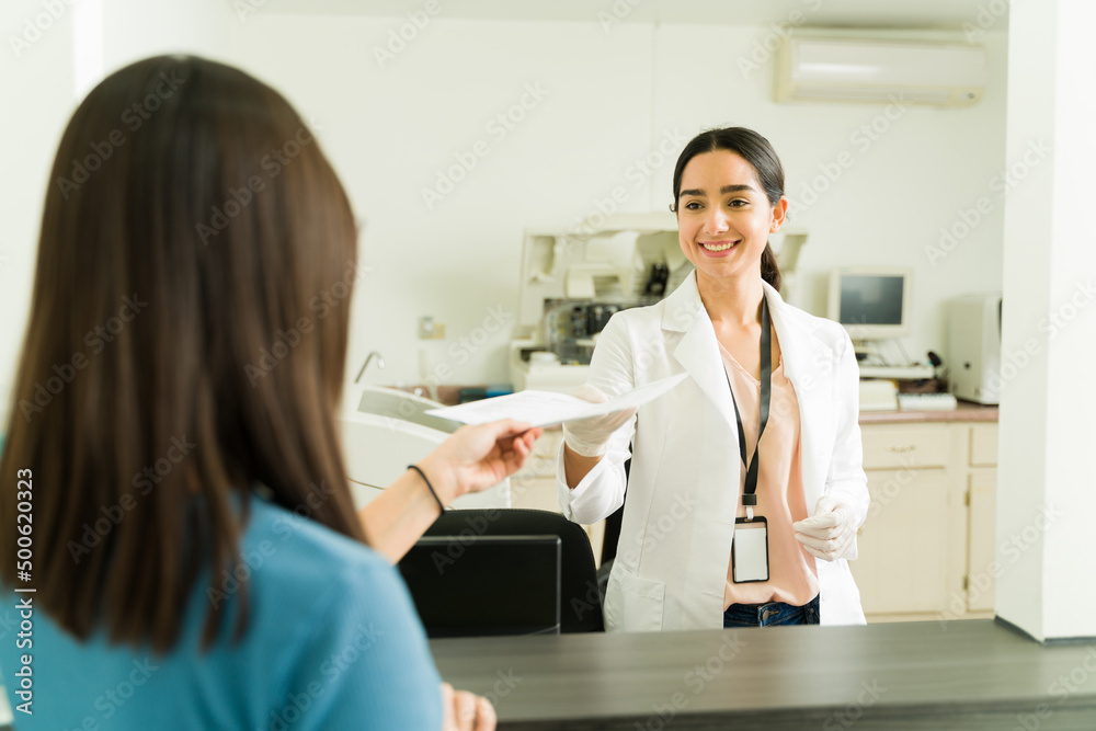 Biochemist smiling to a woman receiving her results Biochemist smiling to a woman receiving her results