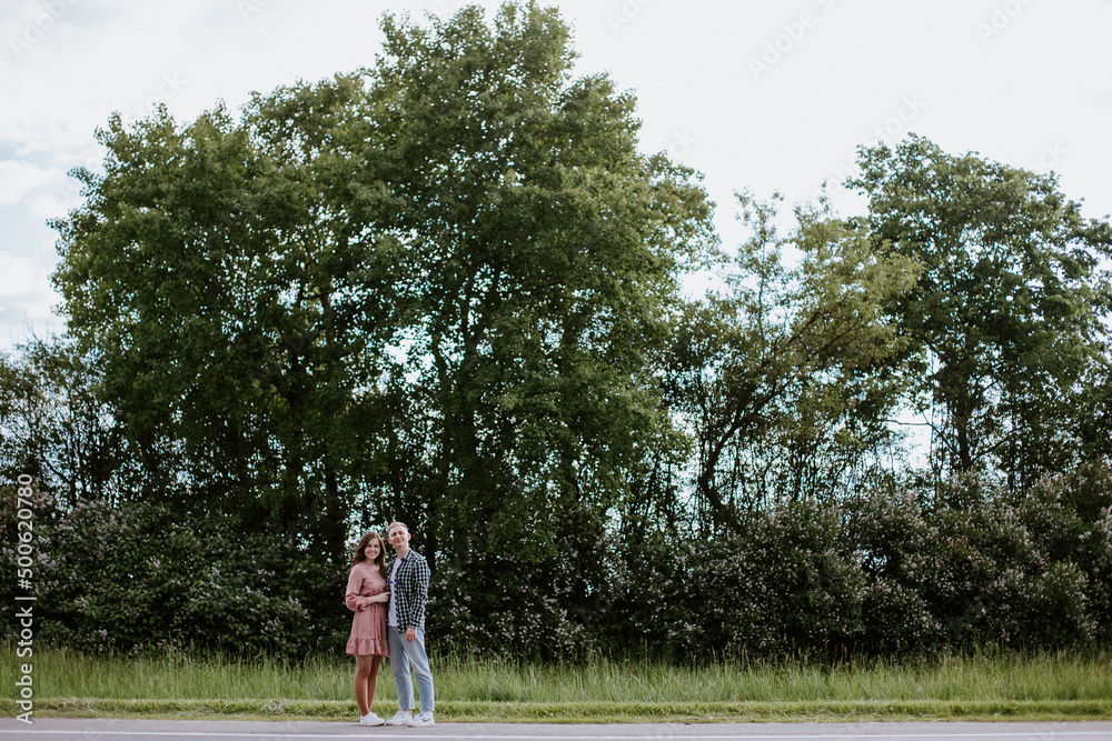 Fototapeta premium Happy young couple, a guy and a girl, look into the camera and smile