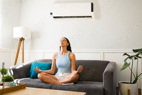Latin woman doing a meditation with the ac on