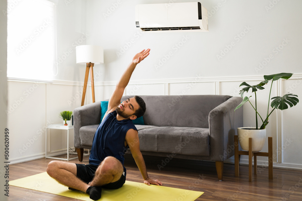 Active man working out while using the air conditioning Active man working out while using the air conditioning