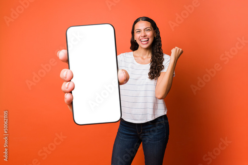 Fotografia Woman feeling happy while using her smartphone