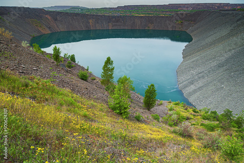 Backfilling and reclamation of a flooded iron ore quarry