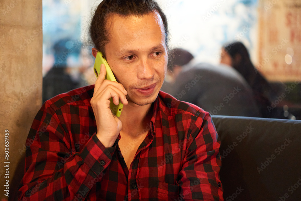 a man in a restaurant with his cellphone a man in a restaurant with his cellphone