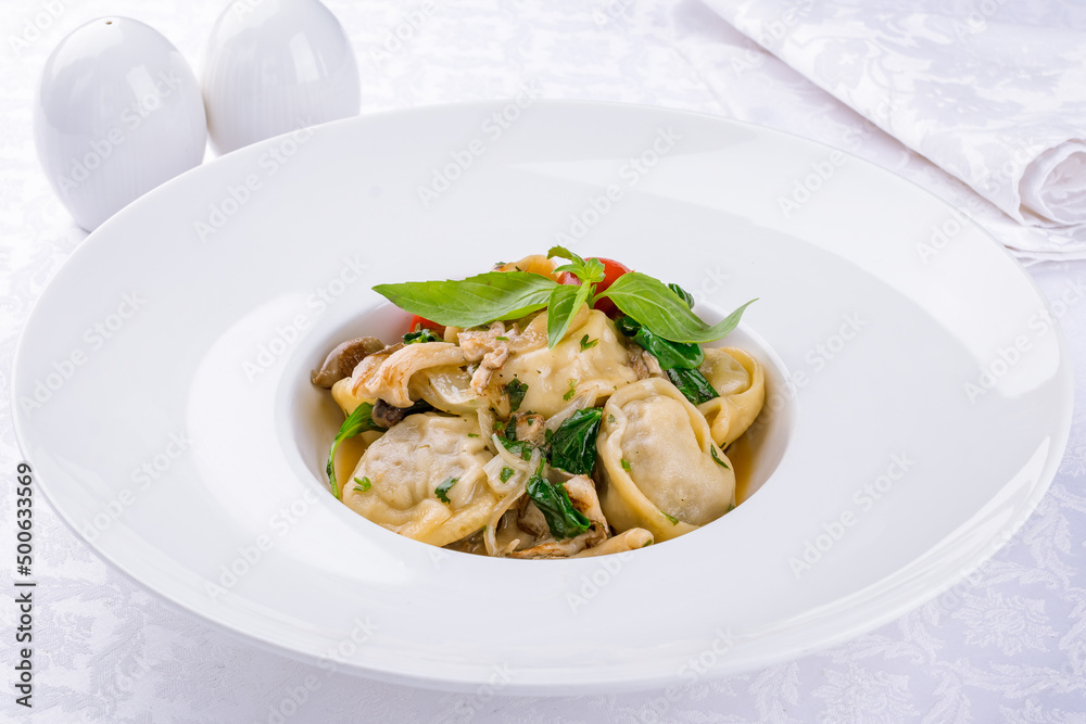 Dumplings with sour cream and herbs and mushrooms on white plate Dumplings with sour cream and herbs and mushrooms on white plate