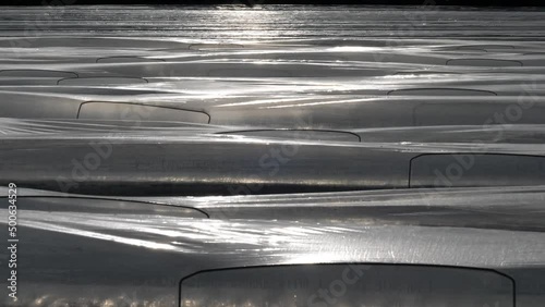 Plastikfolien und Plastikplanen in der Landwirtschaft.
Kultivierung von Spargel im Frühjahr in Deutschland.
Sonnige Reflexe auf der Folie