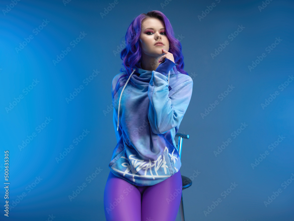 a girl in stylish purple sportswear and with purple hair poses sexually a girl in stylish purple sportswear and with purple hair poses sexually